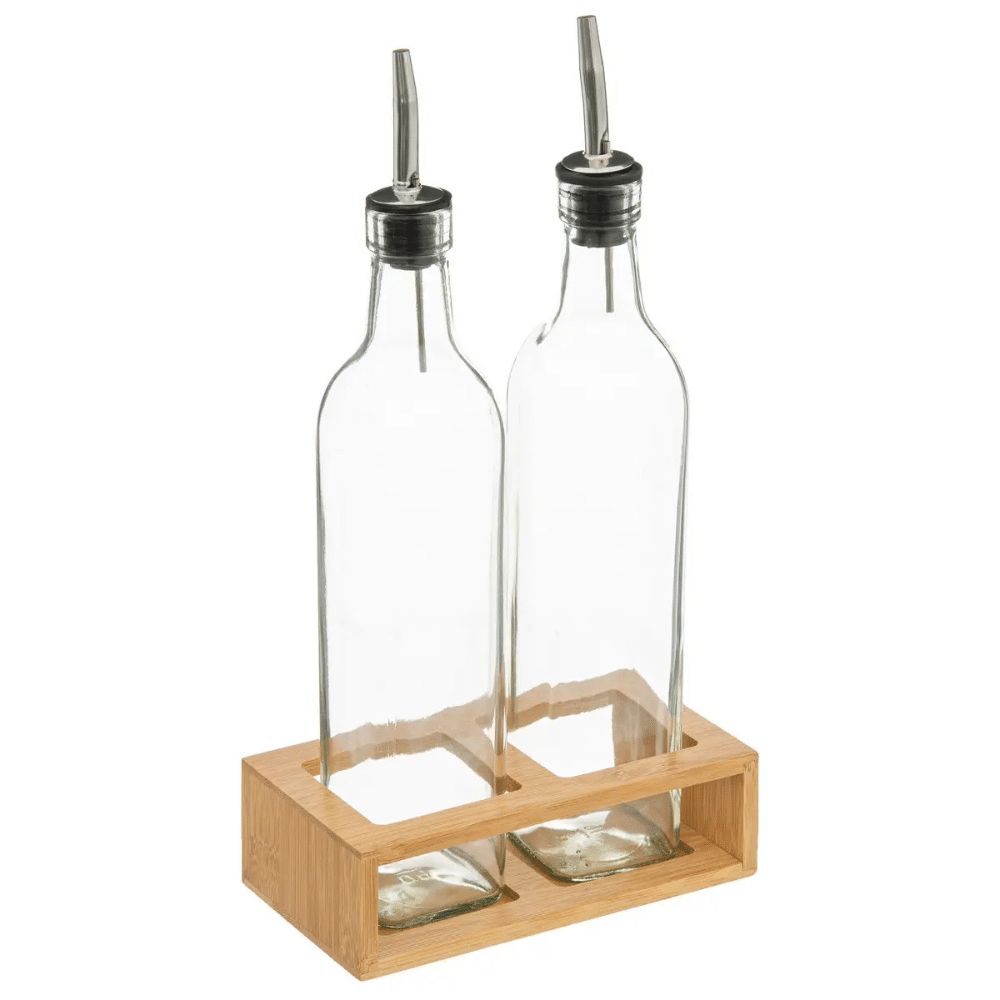 Olie eddike flasker i bambus holder | Two clear glass oil and vinegar cruets with metal pour spouts resting in a light wooden rack. To glasflasker med metalhældetudser og hvide etiketter med teksten Olivenolie og Hørfrøolie i en bambusholder.