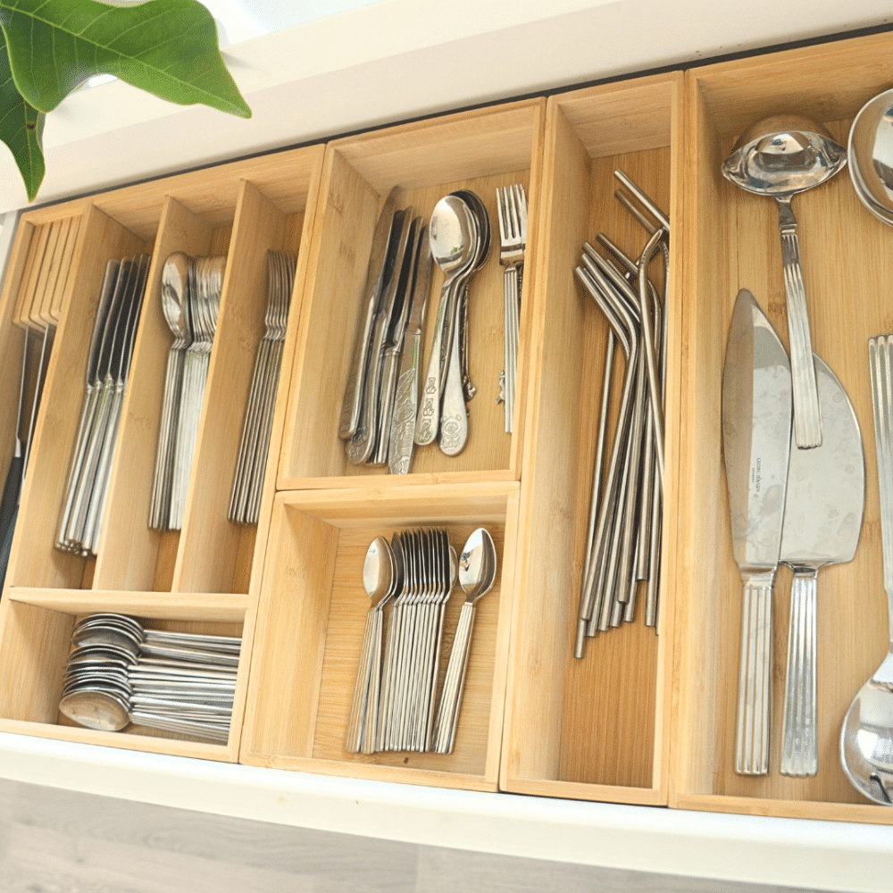 bestikbakker i bambus | Open wooden cutlery drawer with organized sections holding forks, spoons, and knives in a kitchen setting. Bambusindsats i en åben bestikskuffe med plads til køkkenredskaber og serveringsbestik.