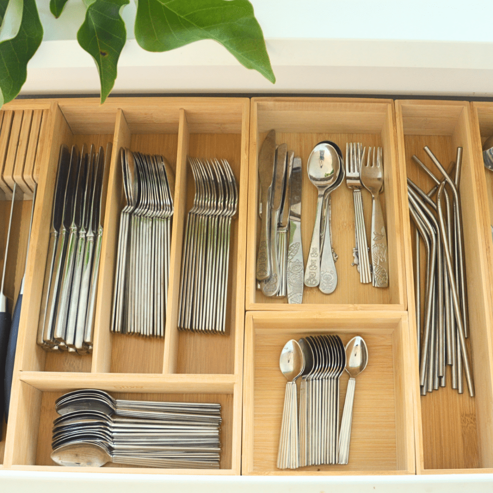 organisering med bambus skuffebakker | Wooden cutlery drawer with sections holding forks, knives, and spoons neatly arranged in compartments. Bambusindsats placeret i en bestikskuffe med knive, gafler, skeer og køkkenredskaber.