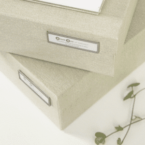 Horizontal labelsklips til organisering af kontorartikler | Gennemsigtig labelklips på en hvid dokumentboks med papiretikette.