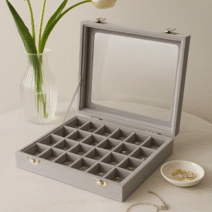 smykkeopbevaring | Smykkeopbevaring med 24 små rum til ringe, ørestikker og armbånd – elegant design på marmorbord med minimalistiske smykker.