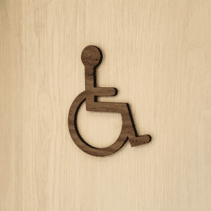 Handicap-skilt i træ med universelt handicap-symbol, udført i valnød eller eg med naturlig træstruktur.
